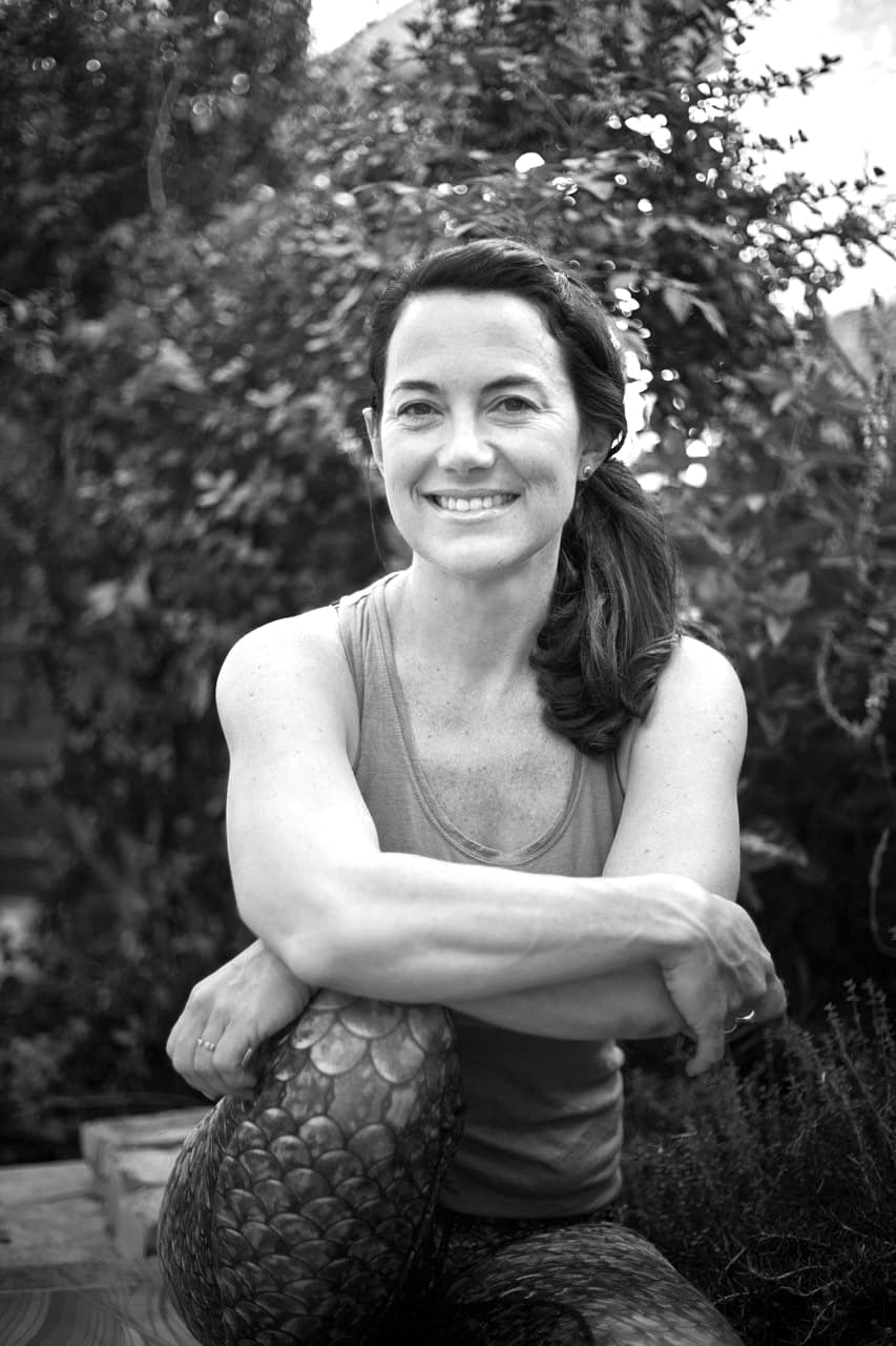 Hanli Prinsloo sits on the ground in a sporty outfit, smiling at the camera