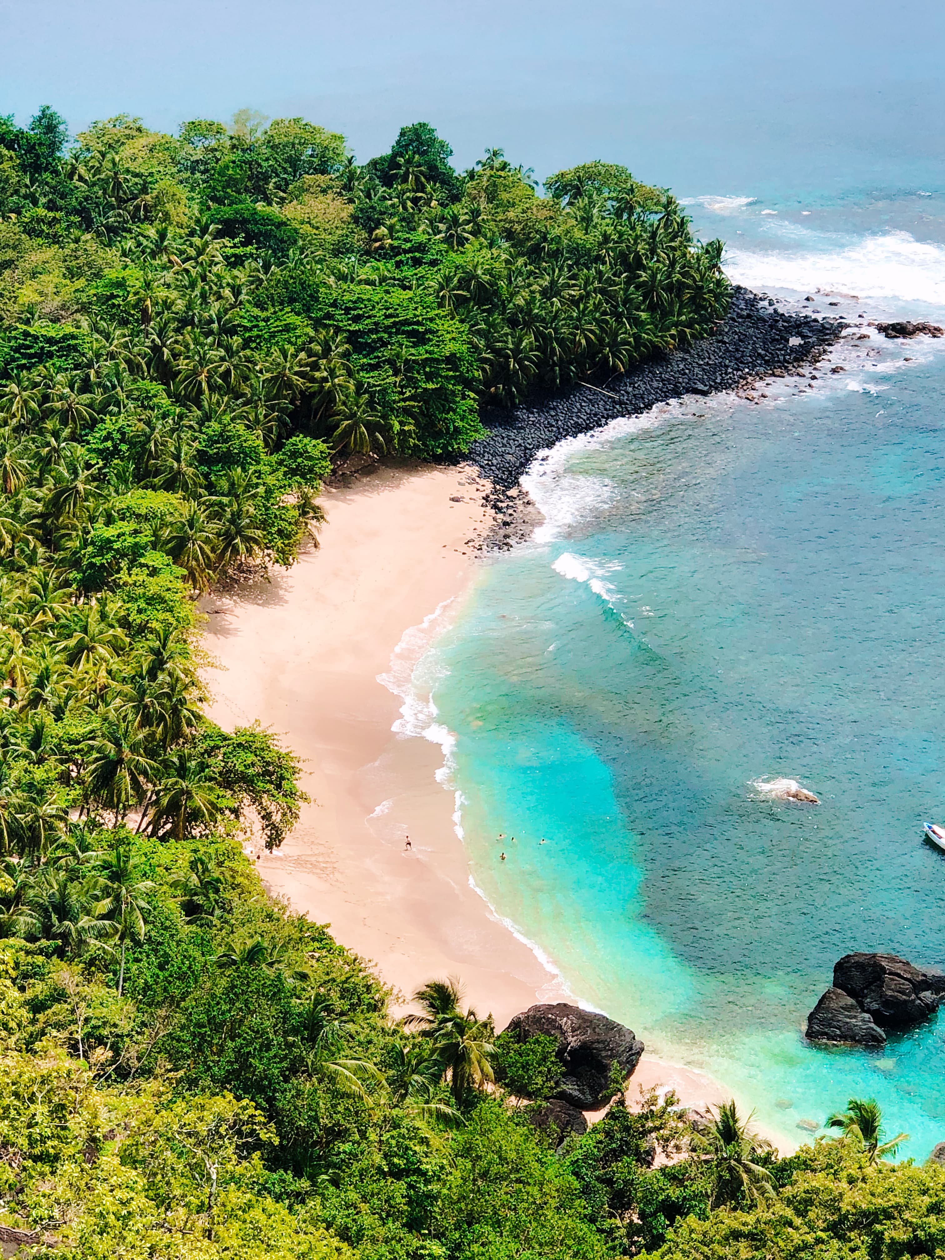 Tropical beach cove with dense jungle vegetation and turquoise water